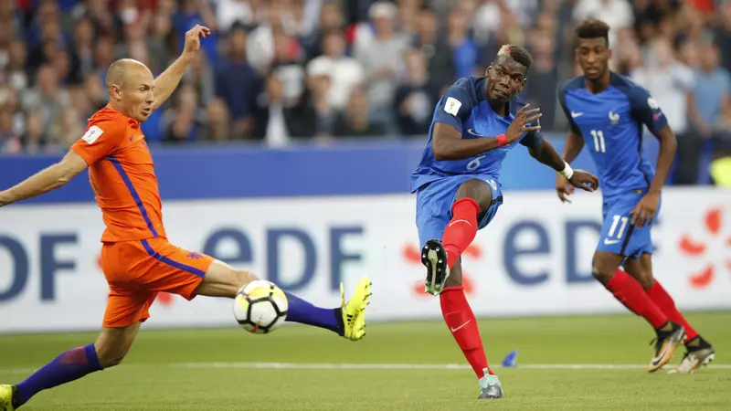 Kapten Timnas Belanda, Arjen Robben (kiri) coba memblok tendangan gelandang Prancis, Paul Pogba pada laga Grup A kualifikasi Piala Dunia 2018 di Stade de France, Jumat (1/9/2017) dini hari WIB. (AP/Christophe Ena)