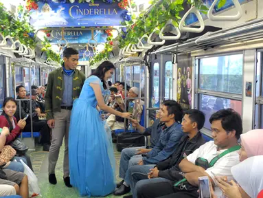 Sebuah rangkaian KRL Commuter Line didekorasi bertema film Cinderella. Tokoh dongeng Cinderella memberikan bunga pada penumpang Commuter Line Jakarta - Bogor, Jakarta, Sabtu (14/02/2015). (Liputan6.com/Andrian M Tunay)