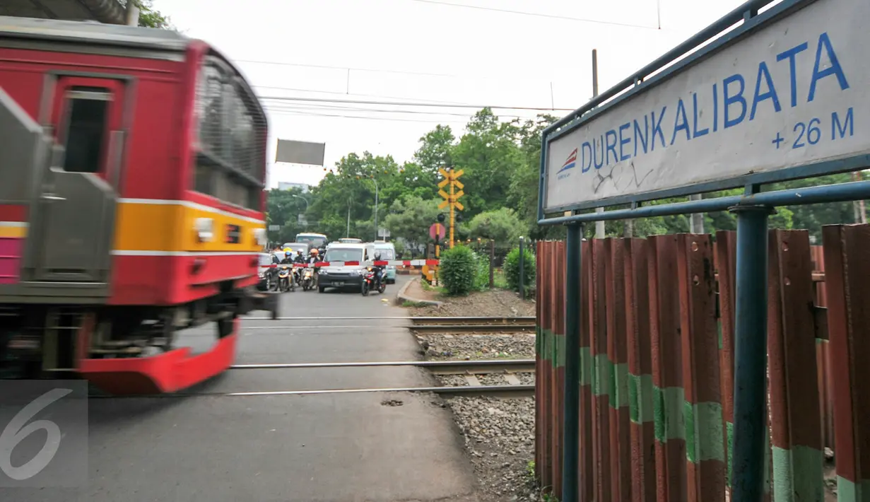 Kereta commuter melintas di perlintasan jalur Kalibata, Jakarta, Jumat (4/12). Untuk menekan angka kecelakaan, Pemprov DKI Jakarta berencana membangun flyover diperlintasan kereta api. (Liputan6.com/Yoppy Renato)