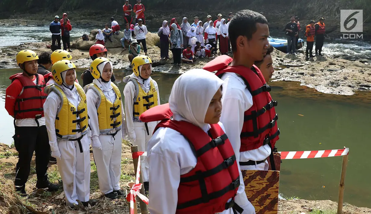 Komunitas Ciliwung bersama pelajar dan warga mengikuti upacara bendera di Sungai Ciliwung, Depok, Jumat (17/8). Upacara di tengah aliran Sungai Ciliwung tersebut dalam rangka memperingati HUT ke-73 Republik Indonesia. (Liputan6.com/Immanuel Antonius)