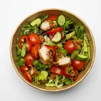Semangkuk chicken salad yang penuh warna dengan potongan dada ayam panggang dan siraman dressing lemon yang terlihat sangat menggugah selera. [Dok/Freepik.com/kaylabridge].