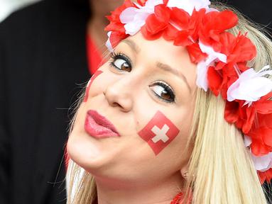 Fans asal  Swiss tersenyum manis saat tertangkap kamera di tribun pada laga grup A Prancis vs Swiss Euro 2016 di Stadion Pierre-Mauroy, Lille (20/6/2016) WIB. (AFP/Francois Lo Presti)