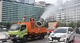 Petugas Dinas Lingkungan Hidup DKI Jakarta menyemprotkan kabut air (water mist) di sepanjang Jalan MH Thamrin, Jakarta Pusat, pada Senin (22/9/2025). (merdeka.com/Arie Basuki)