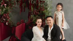 Rianti Cartwright tampil elegen dengan dress putih simpel dan rambut disanggul. Sementara sang suami gagah dengan setelah jas. Dalam momen ini buah hatinya tak kalah mencuri perhatian karena mengenakan dress sleveless selutut. Usianya telah menginjak 4 tahun, senyuman manis yang dipancarkan membuat tak sedikit netizen gemas dengan anak semata wayang Rianti ini. (Liputan6.com/IG/@riantic)