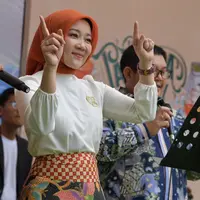 Cantik dan anggun pesona Ibu Cinta di sebuah acara. Ibu Cinta terlihat mengenakan atasan blouse putih dengan sematan bros emas, dipadunya mengenakan rok batik yang serasi dengan hijab oranye polosnya. [Foto: Instagram/ataliapr]