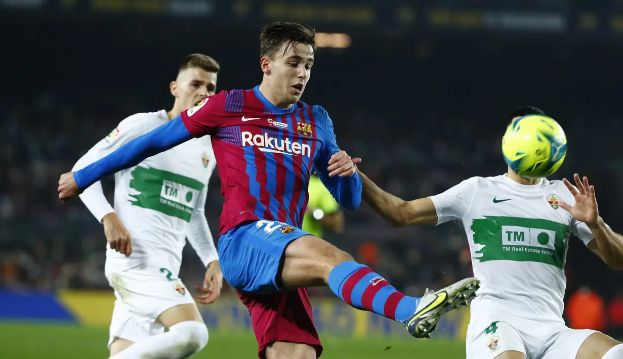 Gelandang Barcelona Nico Gonzalez berebut bola dengan bek Elche Diego Gonzalez pada jornada ke-18 Liga Spanyol di Stadion Camp Nou, Minggu (19/12/2021) dini hari WIB. Barcelona menang 3-2 atas Elche. (AP Photo/Joan Monfort)
