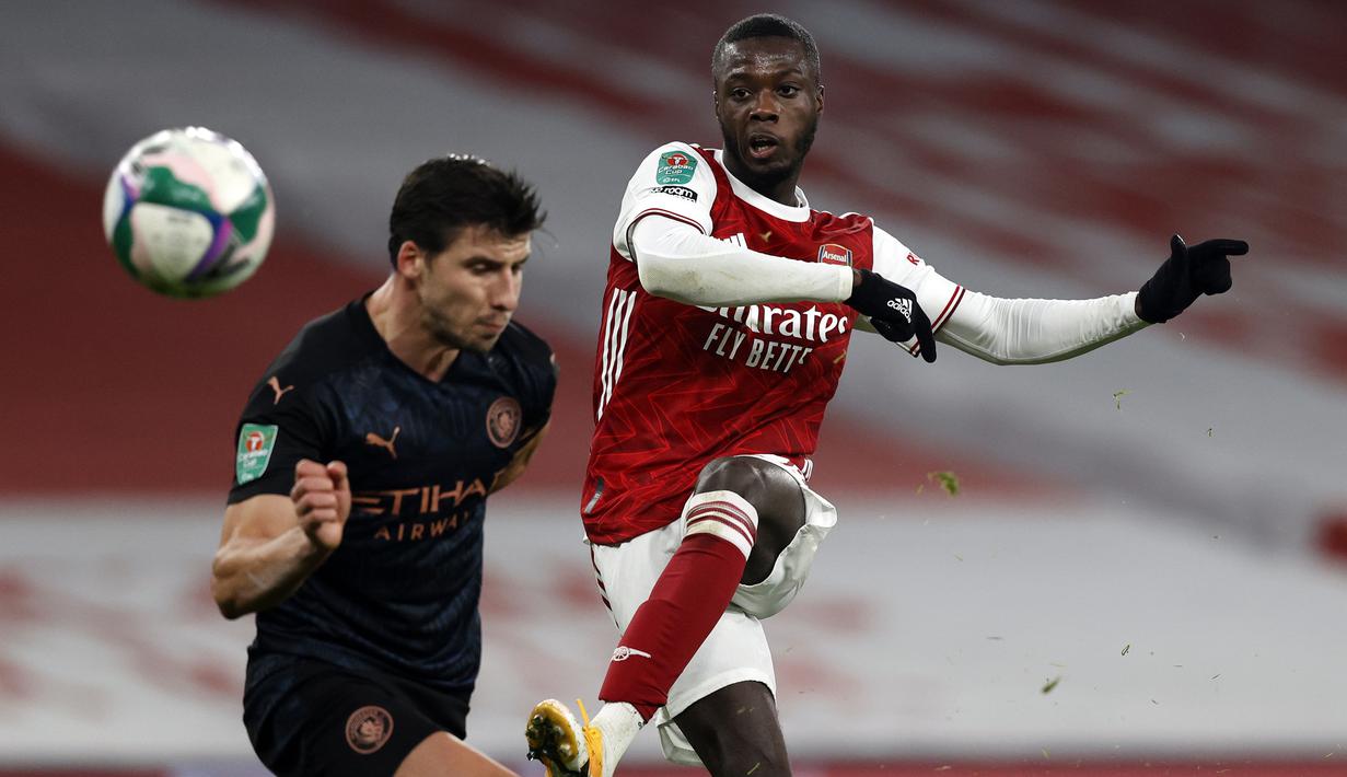 Gelandang Arsenal, Nicolas Pepe (kanan), melepaskan tendangan dalam laga perempatfinal Piala Liga Inggris Carabao Cup melawan Manchester City di Emirates Stadium, London, Selasa (22/12/2020). Arsenal kalah 1-4 dari Manchester City. (AFP/Adrian Dennis)