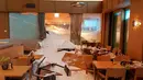 Petugas membersihkan longsoran salju yang masuk ke dalam Hotel Saentis di Schwaegalp, Swiss, Jumat (11/1). Badai salju tengah melanda Swiss dan sejumlah negara di Eropa. (Gian Ehrenzeller/Keystone via AP)