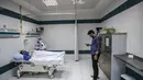 Mahmoud El Komy, seorang insinyur mekatronika, menguji prototipe robot CIRA-03 kendali jarak jauh yang didanai sendiri untuk membantu dokter dalam menjalankan tes pada pasien yang dicurigai COVID-19 di rumah sakit swasta di kota Tanta, Mesir pada 20 Maret 2021. (Khaled DESOUKI/AFP)