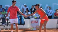 Petenis Serbia , Novak Djokovic bersalaman dengan Olga Danilovic selama pertandingan ganda campuran mereka di sebuah turnamen di Zadar, Kroasia (19/6/2020). Novak Djokovic dan istrinya menderita COVID-19.  (AP Photo/Zvonko Kucelin)