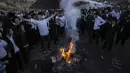 Orang-orang Yahudi Ultra Ortodoks menari di sekitar api unggun saat perayaan Lag BaOmer di situs makam tradisional Rabbi Shimon Bar Yochai di Gunung Meron, Israel, Kamis (19/5/2022). Orang Israel menyalakan api unggun selama perayaan Lag BaOmer untuk memperingati berakhirnya wabah yang dikatakan telah memusnahkan orang Yahudi di zaman Romawi. (AP Photo/Ariel Schalit)