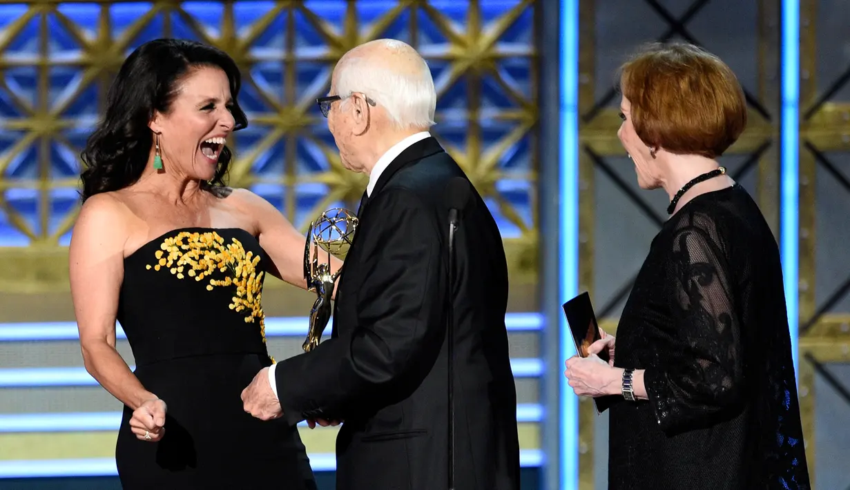 Aktris AS, Julia Louis-Dreyfus saat akan menerima trofi di atas panggung Emmy Awards 2017 di Los Angeles, Minggu (17/9). Tahun ini Julia secara resmi memegang rekor sebagai pemenang Emmy terbanyak untuk satu akting. (Chris Pizzello/Invision/AP)