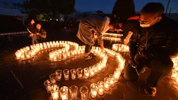 Seorang pria menyalakan lilin yang membentuk angka 3.11 saat upacara peringatan bencana gempa tsunami yang terjadi pada tahun 2011 di Natori, Prefektur Miyagi, Jepang (11/3). Dalam peristiwa tersebut sekitar 18 ribu orang tewas. (AFP/Kazuhiro Nogi)