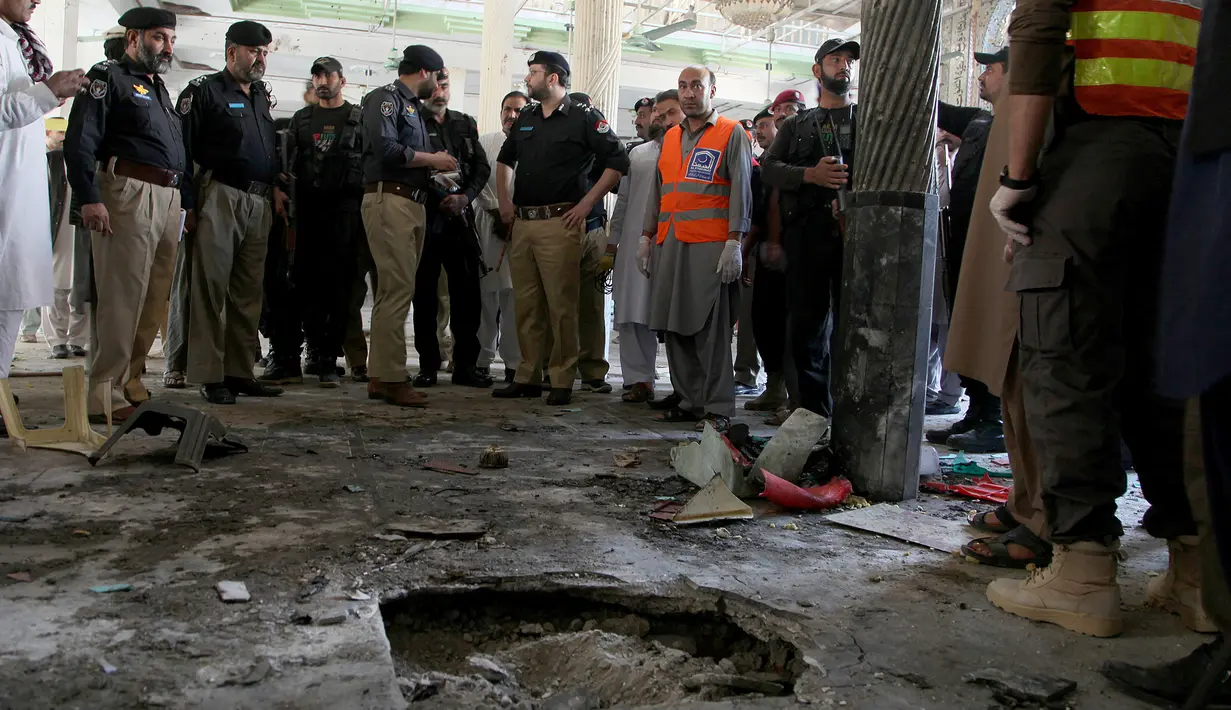 Petugas kepolisian memeriksa lokasi ledakan bom di sebuah madrasah di kota Peshawar, Pakistan, Selasa (27/10/2020). Berdasarkan keterangan saksi, ada seseorang membawa tas diduga berisi bom di dalam kelas dan meninggalkan ruangan sebelum ledakan. (AP Photo/Muhammad Sajjad)
