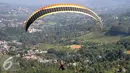 Olahraga Paralayang menjadi pilihan warga yang berkunjung ke Puncak Pass, Bogor, Jumat (6/4). Olahraga yang memacu adrenalin ini dipatok dengan harga Rp. 350 Ribu. (Liputan6.com/Johan Tallo)