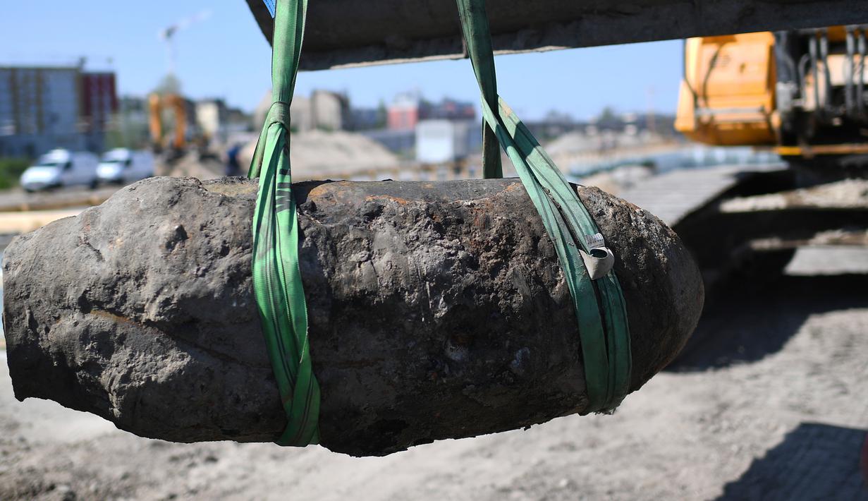 Wujud bom perang dunia II saat diangkat alat berat di Berlin, Jerman, Jumat (20/4). Bom yang ditemukan oleh pekerja konstruksi tersebut masih dalam kondisi aktif. (Britta Pedersen/dpa via AP)