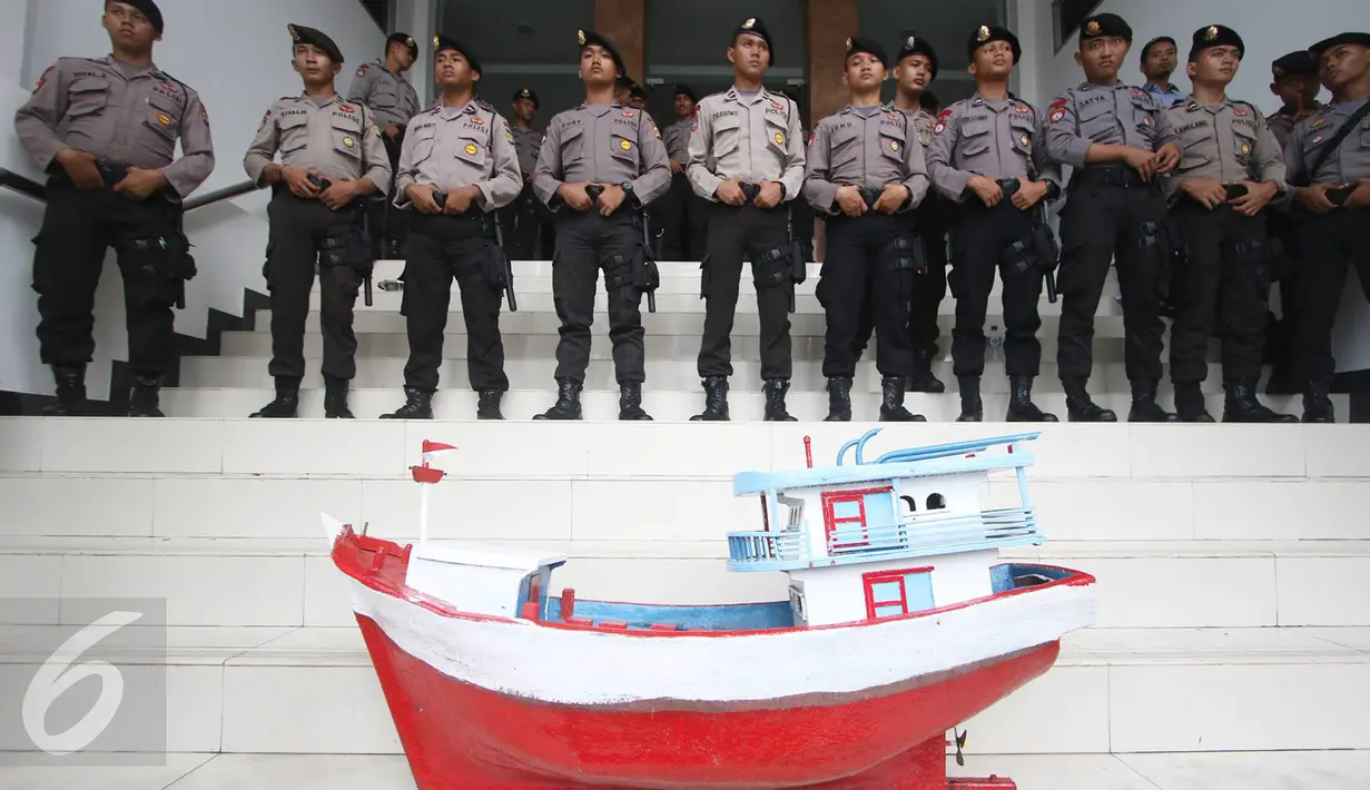Miniatur kapal yang dibawa nelayan diletakan di dekat sejumlah aparat kepolisian yang berjaga di halaman PTTUN, Jakarta, Selasa (30/8). Para nelayan meminta hakim PTTUN menolak banding penerbitan izin reklamasi pulau G. (Liputan6.com/Immanuel Antonius)