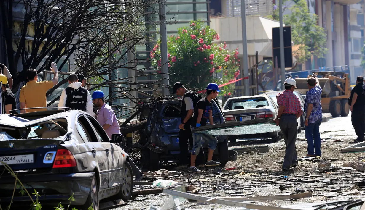 Warga dan petugas saat memeriksa kerusakan yang terjadi di Bank Blom pasca ledakan di Beirut, Lebanon (13/6).Bom tersebut menghancurkan gedung, fasilitas dan kendaraan yang terparkir dekat gedung. (REUTERS/Jamal Saidi)