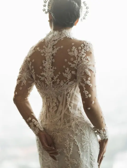 Kebaya pengantin putih dengan material lace tersebut memiliki motif floral. Yang diperindah dengan payet menonjol. [Foto: @mordenco]