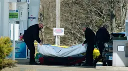 Petugas medis mengevakuasi korban penembakan di sebuah pom bensin di Enfield, Nova Scotia, Minggu (19/4/2020). Aksi itu ia lancarkan dalam kurun waktu selama 12 jam, lapor pihak berwenang. (Tim Krochak/The Canadian Press via AP)