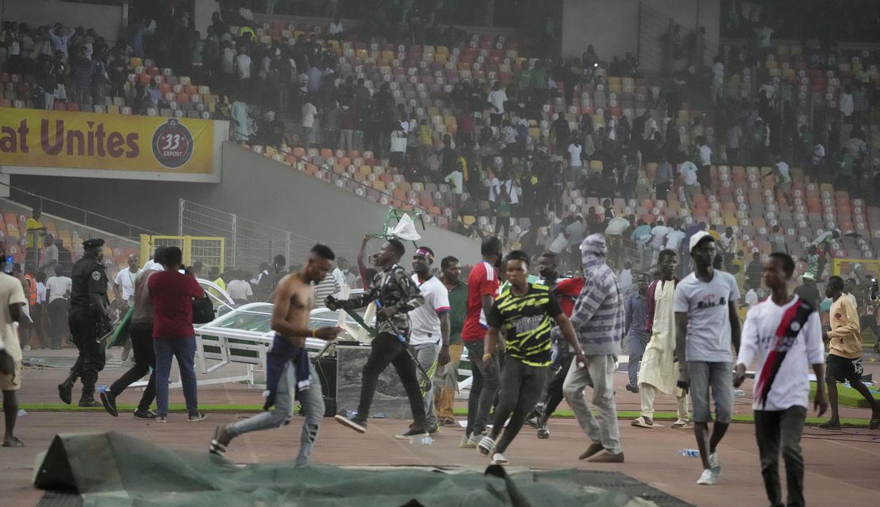 Mereka pun melakukan pelemparan dan pengrusakan berbagai objek di lapangan. (AP/Sunday Alamba)