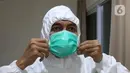 dr Rahmadi Iwan Guntoro, Sp.P merapikan maskernya di Rumah Sakit Haji, Jakarta, Kamis (9/4/2020). Tenaga medis yang menggunakan alat pelindung diri pada tingkatan perlindungan ketiga, yaitu dokter, perawat, dan petugas laboran (laboratorium). (Liputan6.com/Herman Zakharia)