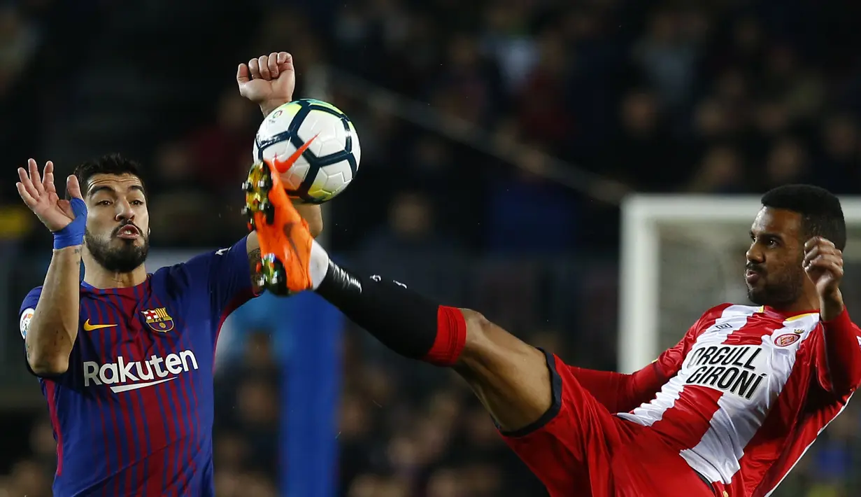 Duel pemain Barcelona, Luis Suarez (kiri) dan pemain Girona, Jonas Ramalho pada La Liga Santander di Camp Nou stadium, Barcelona, (24/2/2018). Barcelona menang telak 6-1. (AP/Manu Fernandez)