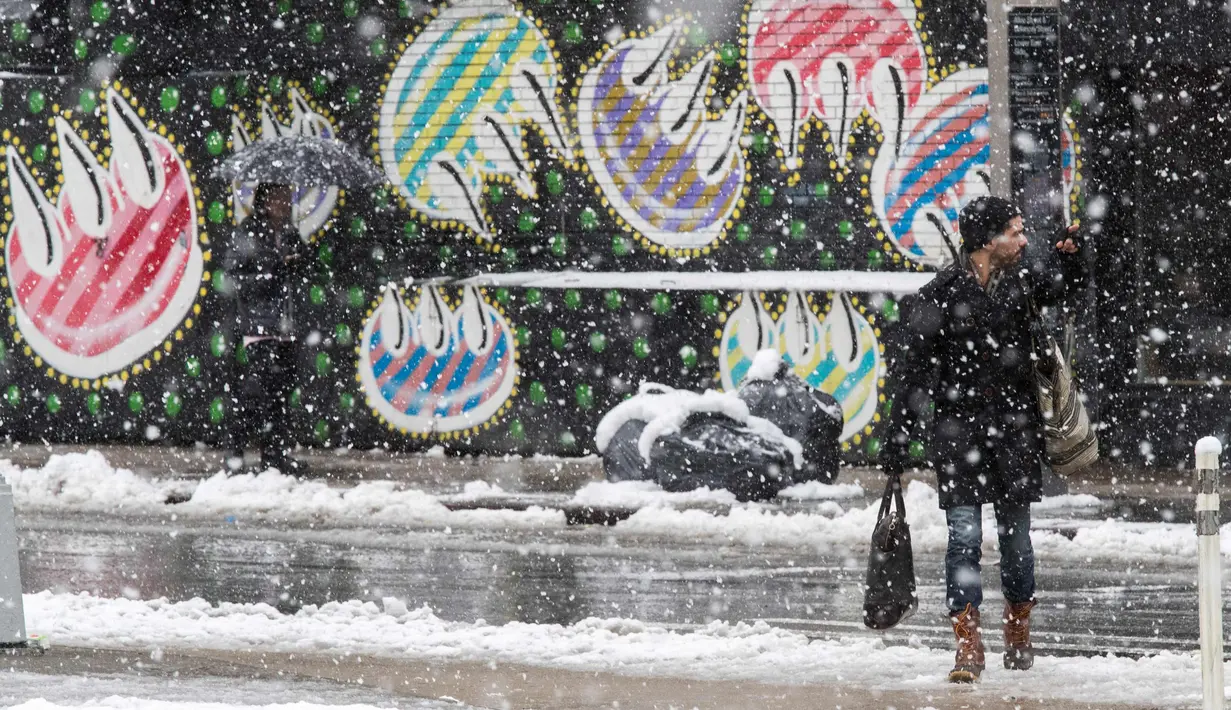 Seorang pria menunggu taksi saat di New York (21/3). Badai salju yang melanda sebagian Amerika Serikat telah membawa salju dan angin kencang. (AP Photo / Mary Altaffer)