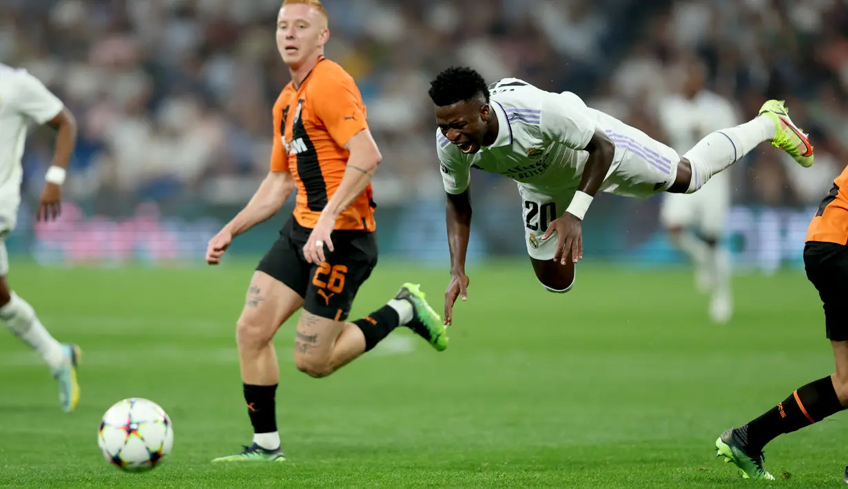 Pemain depan Real Madrid Vinicius Junior bersaing dengan bek Shakhtar Donetsk Yukhym Konoplya dalam matchday ketiga Grup F Liga Champions 2022/2023 di Santiago Bernabeu, Kamis dini hari WIB (6/10/2022). Dengan kemenangan ini Real Madrid makin memperkokoh posisinya di puncak klasemen setelah mengumpulkan 9 poin. (Photo by Thomas COEX / AFP)