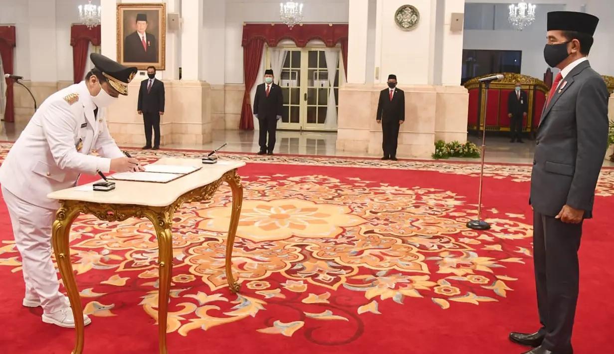 Wakil Gubernur DKI Jakarta Ahmad Riza Patria menandatangani dokumen disaksikan Presiden Joko Widodo usai pelantikan di Istana Negara, Jakarta, Rabu (15/4/2020). (Biro Pers Kepresidenan)