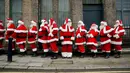 Sejumlah pria mengenakan kostum Santa Claus berbaris saat sesi pemotretan di Ragged School Museum di London (16/11). Sekolah ini juga mengajarkan teknik mengembus serta tertawa ho ho ho khas Santa Claus. (AP Photo/Matt Dunham)