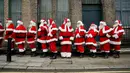 Sejumlah pria mengenakan kostum Santa Claus berbaris saat sesi pemotretan di Ragged School Museum di London (16/11). Sekolah ini juga mengajarkan teknik mengembus serta tertawa ho ho ho khas Santa Claus. (AP Photo/Matt Dunham)