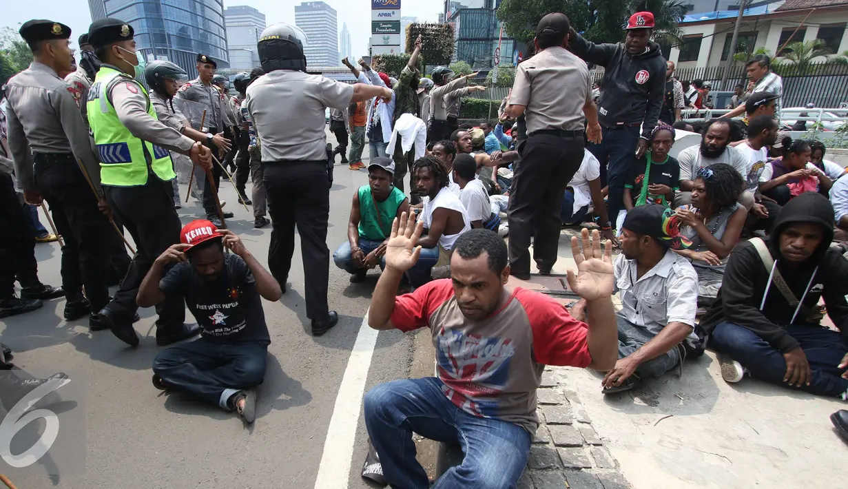 Petugas saat menertibkan mahasiswa saat bentrok dengan petugas kepolisian saat aksi perayaan ekspresi identitas Papua di kawasan Bunderan Hotel Indonesia, Jakarta Pusat, Selasa (1/12). (Liputan6.com/Immanuel Antonius)