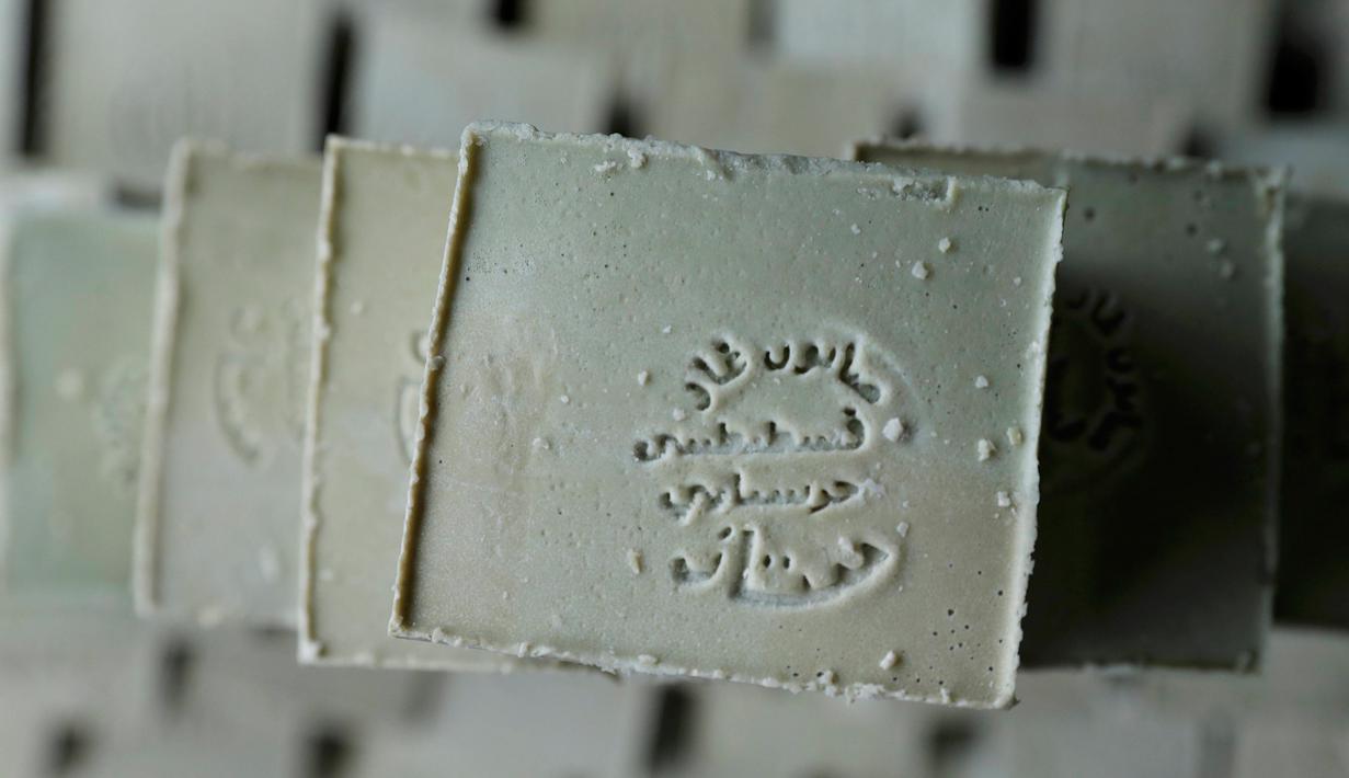 Sabun yang telah dicetak memasuki proses penjemuran, Paris, Kamis (22/12). Awalnya berwarna hijau, setelah menjalani proses penjemuran akan berubah menjadi kuning kecoklatan. (REUTERS / Christian Hartmann)