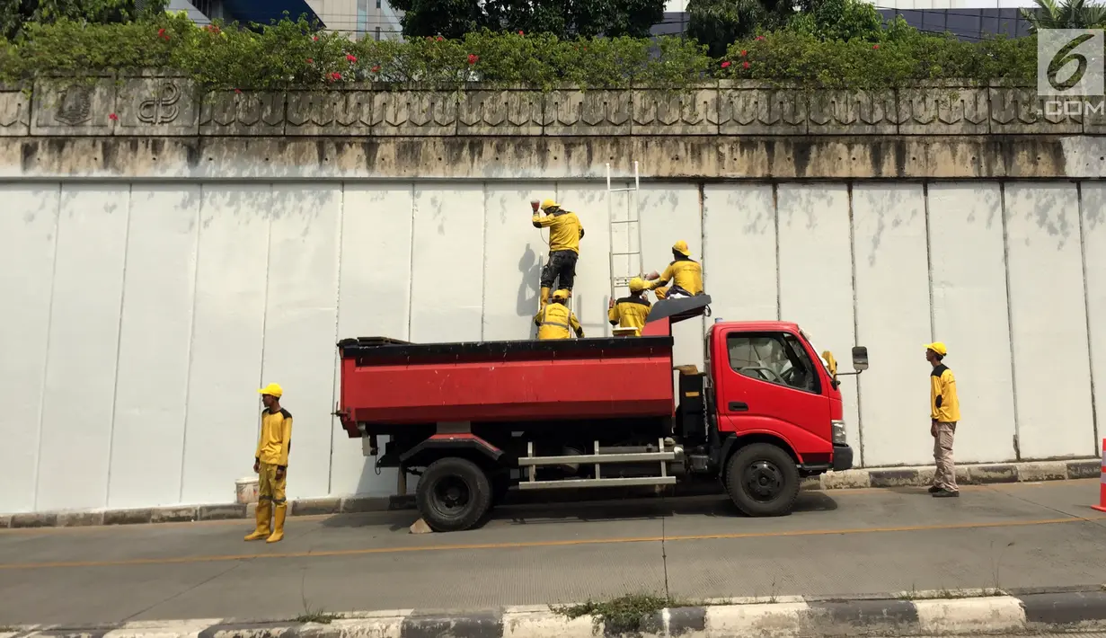 Pasukan Kuning mengecat dinding Underpass Kebayoran Baru, Jakarta Selatan, Kamis (1/2). Pengecatan dilakukan sebagai bentuk perawatan. (Liputan6.com/Immanuel Antonius)