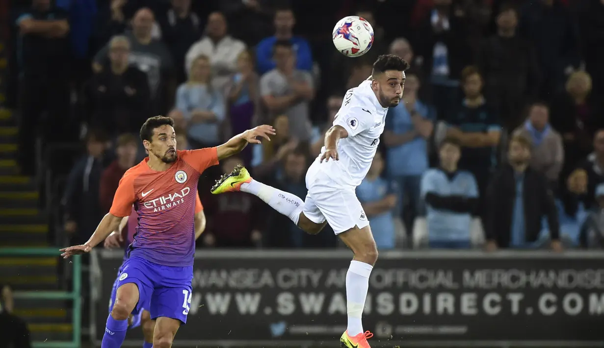 Pemain Machester City, Jesus Navas mencoba menghadang  pemain Swansea City, Neil Taylor pada laga Piala Liga Inggris di Liberty Stadium, Kamis (22/9/2016) dini hari WIB.  (Reuters/Rebecca Naden)