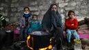 Warga Palestina menghangatkan diri di sekitar api tungku di area permukiman kumuh sebuah kamp pengungsi saat cuaca badai di Kota Khan Younis, Jalur Gaza selatan, pada 26 November 2020. (Xinhua/Yasser Qudih)