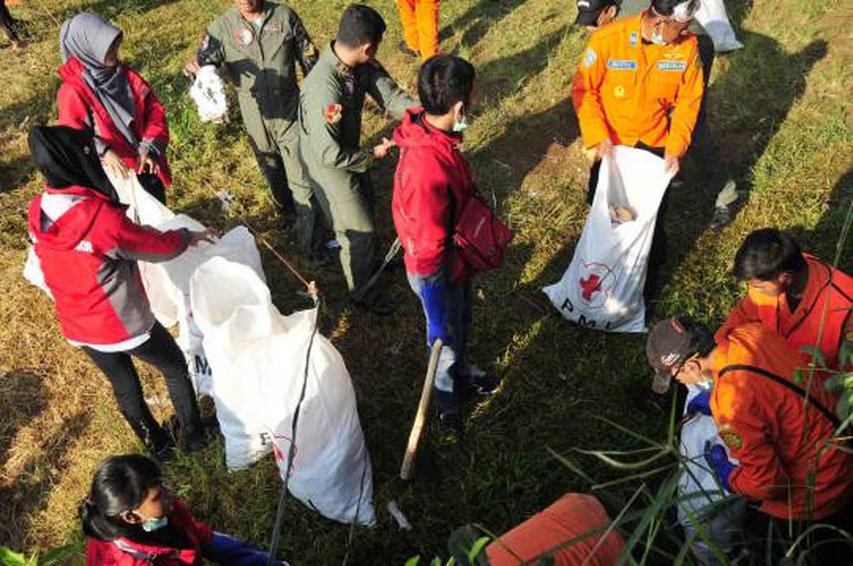 Relawan PMI dan TNI dibantu warga sekitar melakukan bersih   bersih di 