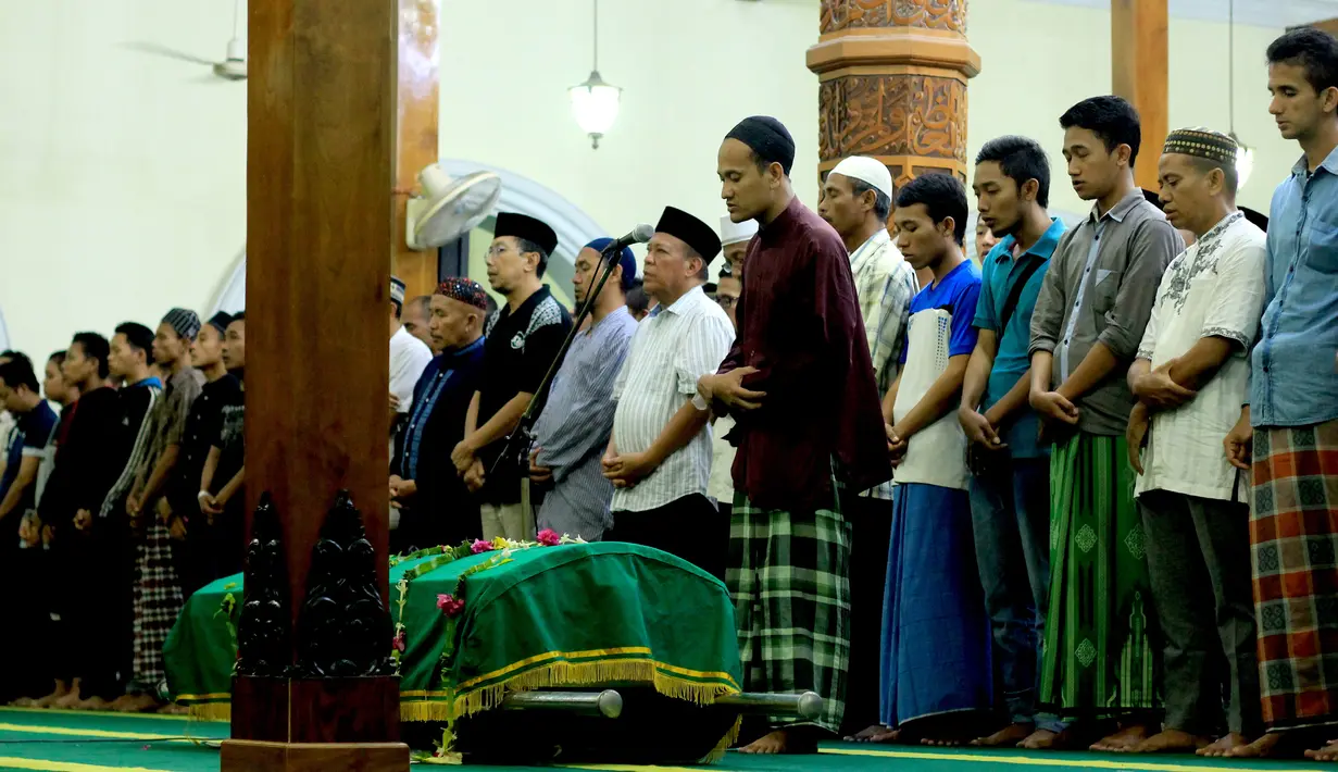 Keluarga dan kerabat menyalatkan jenazah Kiper Persela Lamongan, Choirul Huda di Jawa Timur (15/10). Choirul Huda sempat mendapat pertolongan dengan alat bantu oksigen, namun nyawanya tak tertolong. (AFP Photo/Juni Kriswanto)