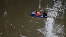 Masih banyak warga bantaran kali Ciliwung Jakarta yang memanfaatkan air kali untuk kehidupan sehari - hari. Tampak seorang pemulung mengumpulkan sampah plastik yang ada di kali Ciliwung Jakarta, Jumat (20/2/2015). (Liputan6.com/JohanTallo)