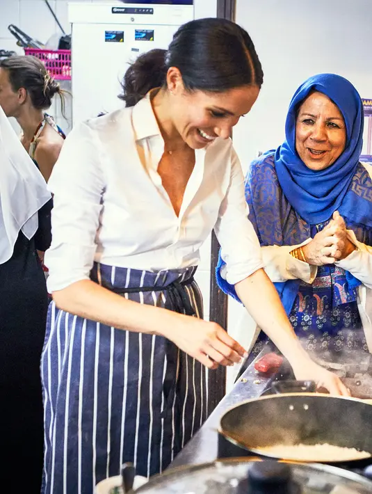 Duchess of Sussex, Meghan Markle saat memasak bersama kelompok Hubb Community Kitchen yang mayoritas beragama Islam saat  melakukan proyek amal di Al Manaar Muslim Cultural Heritage Centre, London, Inggris (19/7). (Jenny Zarins/Kensington Palace via AP)