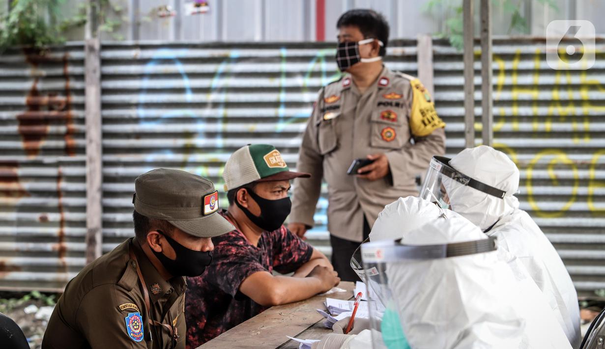 Petugas medis saat menggelar swab test COVID-19 di Pasar Tasik, Jakarta, Kamis (2/7/2020). Tes yang dilakukan secara acak bagi pedagang itu bertujuan untuk mendeteksi serta mencegah penyebaran COVID-19 di kawasan Pasar Tasik. (Liputan6.com/Faizal Fanani)