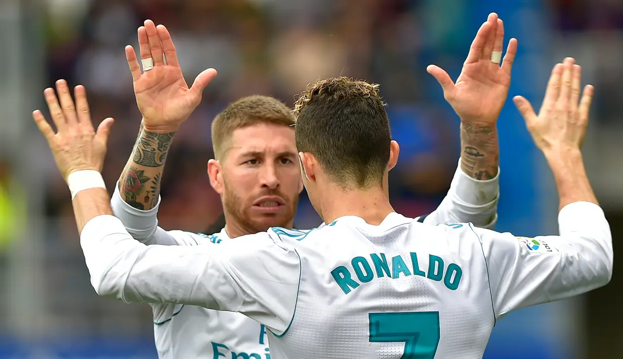 Pemain Real Madrid, Cristiano Ronaldo (kanan) menghampiri Sergio Ramos usai mencetak gol ke gawang Eibar pada laga La Liga di Stadion Ipurua, Eibar. Sabtu (10/3). Real Madrid melumat Eibar dengan skor 2-1. (ANDER GILLENEA/AFP)