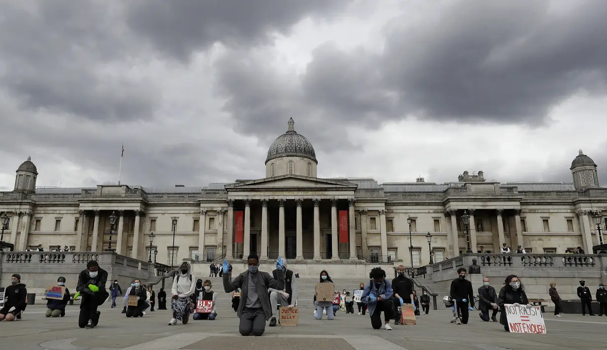 Demonstran berlutut untuk memprotes kematian George Floyd di Trafalgar Square, London, Inggris, Jumat (5/6/2020). Kematian pria kulit hitam George Floyd saat ditangkap oleh polisi Amerika Serikat memicu kemarahan di sejumlah negara. (AP Photo/Kirsty Wigglesworth)