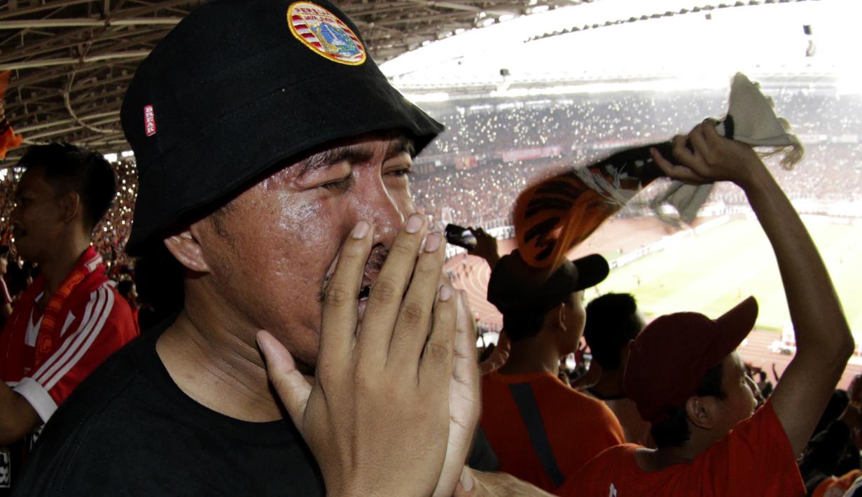Suporter Persija Jakarta menangis saat merayakan gelar juara Liga 1 di SUGBK, Jakarta, Minggu (09/12). Persija menang 2-1 atas Mitra Kukar. (Bola.com/M Iqbal Ichsan)