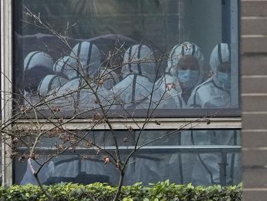 Anggota tim Organisasi Kesehatan Dunia (WHO) terlihat mengenakan APD selama kunjungan lapangan ke Pusat Pengendalian dan Pencegahan Penyakit Hewan Hubei di Wuhan di provinsi Hubei, China tengah, Selasa (2/2/2021).  Tim WHO tengah menyelidiki asal-usul virus corona. (AP Photo/ Ng Han Guan)