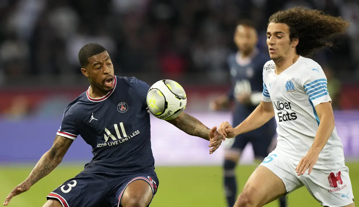 Bek Paris Saint-Germain (PSG) Presnel Kimpembe berebut bola dengan gelandang Olympique Marseille Matteo Guendouzi pada laga Liga Prancis pekan ke-32 di Parc des Princes, Senin (18/4/2022) dini hari WIB. PSG vs Marseille berakhir dengan skor 2-1. (AP Photo/Francois Mori)