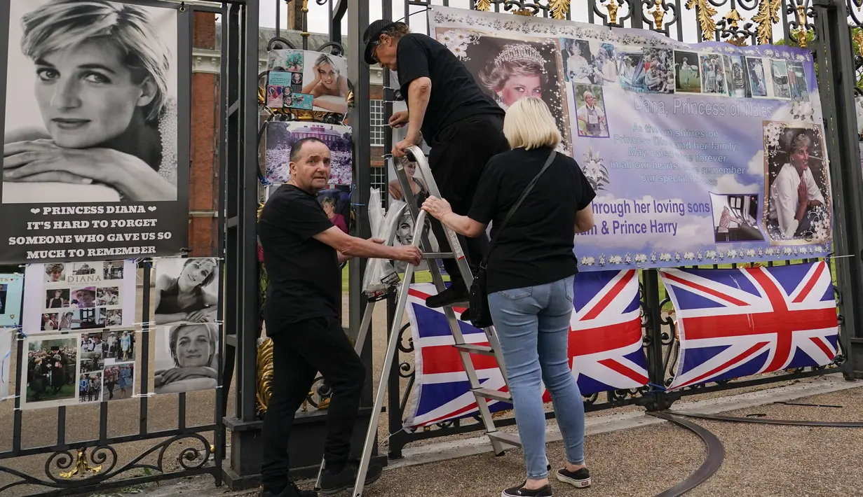 Seorang perempuan berfoto di dekat potret Putri Diana yang dipajang di gerbang Istana Kensington, di London, Senin, 29 Agustus 2022. Minggu ini, tepatnya pada 31 Agustus, menandai peringatan 25 tahun kematian Putri Diana dalam kecelakaan mobil di Paris. (AP Photo/Alberto Pezzali)