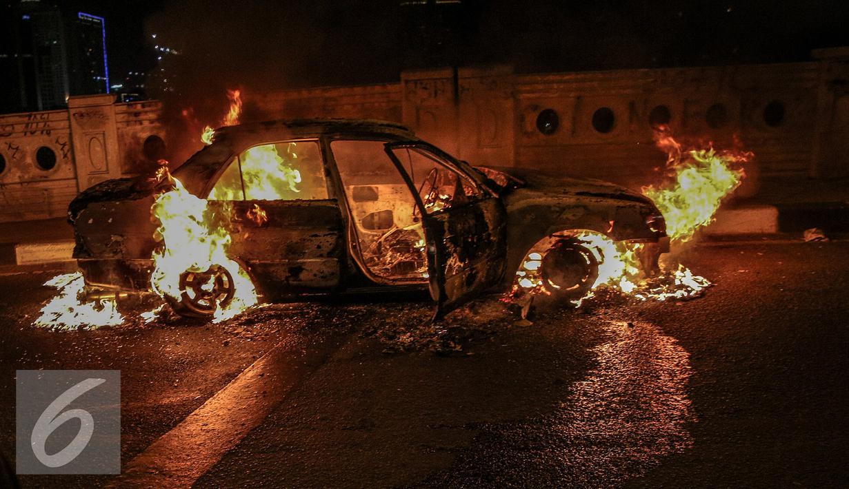 Mobil sedan bernopol B 8679 LG yang terbakar di jalan layang Latuharhari, Jakarta, Kamis (18/9/2015). Kejadian terjadi sekitar pukul 22.39 WIB, diduga kebakaran akibat konsleting listrik yang terjadi dibagian depan kap mobil. (Liputan6.com/Faizal Fanani)