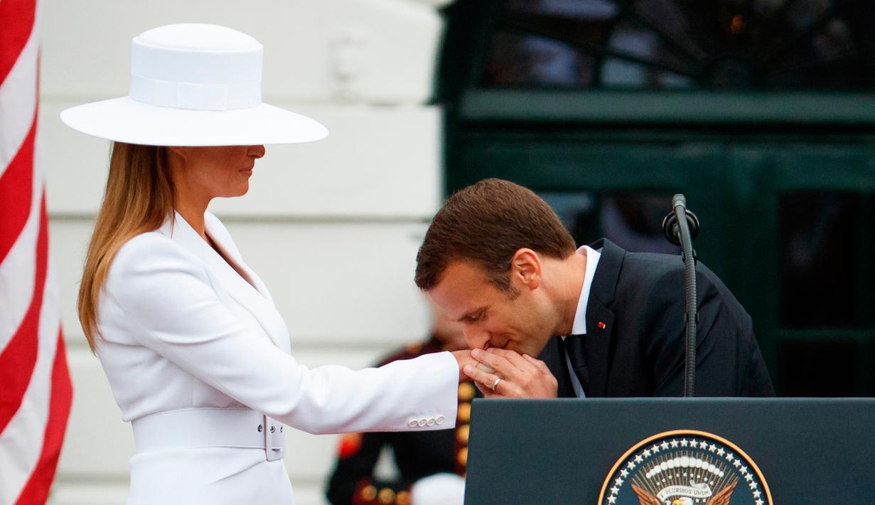 Presiden Prancis Emmanuel Macron mencium tangan Istri Presiden AS Donald Trump, Melania Trump saat upacara menyambut kedatangan tamu negara di Gedung Putih, Washington (24/4). (AP Photo/Evan Vucci)